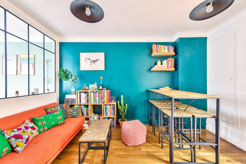 Mittelgroßes, Offenes Eklektisches Wohnzimmer ohne Kamin mit Hausbar, grüner Wandfarbe, braunem Holzboden, TV-Wand und braunem Boden in Paris