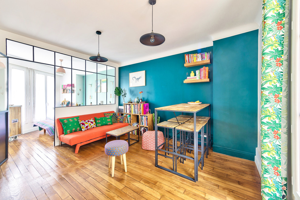 Mittelgroßes, Offenes Eklektisches Wohnzimmer ohne Kamin mit Hausbar, grüner Wandfarbe, braunem Holzboden, TV-Wand und braunem Boden in Paris