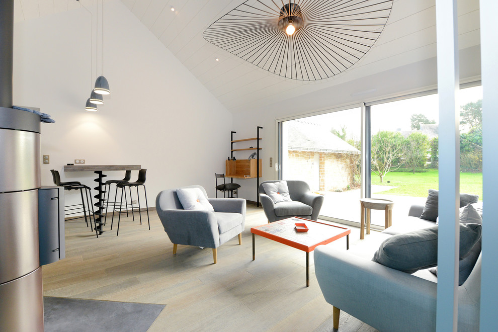 Mittelgroßes, Fernseherloses, Offenes Modernes Wohnzimmer mit weißer Wandfarbe, hellem Holzboden, Kaminofen und Kaminumrandung aus Metall in Nantes