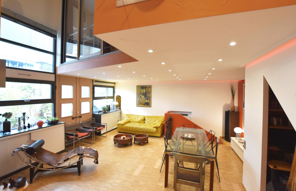 Modelo de sala de estar abierta contemporánea de tamaño medio con parades naranjas y suelo de madera clara