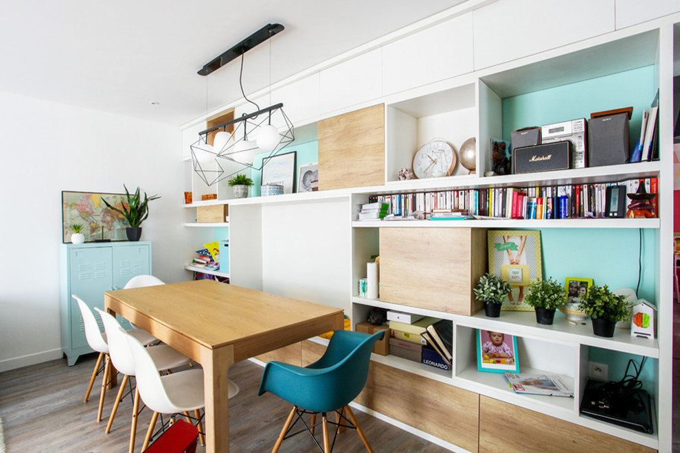 Imagen de sala de estar con biblioteca abierta escandinava grande con paredes blancas, suelo de madera en tonos medios, televisor independiente y suelo marrón