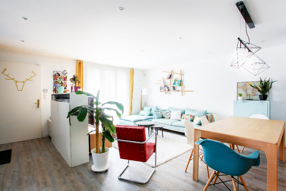 Foto di un grande soggiorno scandinavo aperto con libreria, pareti bianche, pavimento in legno massello medio, TV autoportante e pavimento marrone