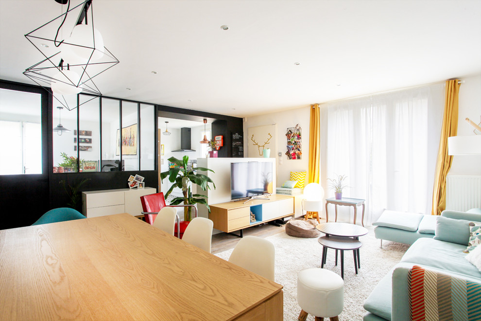 Immagine di un grande soggiorno scandinavo aperto con libreria, pareti bianche, pavimento in legno massello medio, TV autoportante e pavimento marrone