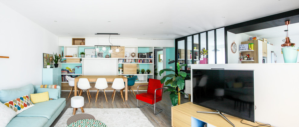 Foto di un grande soggiorno nordico aperto con libreria, pareti bianche, pavimento in legno massello medio, TV autoportante e pavimento marrone