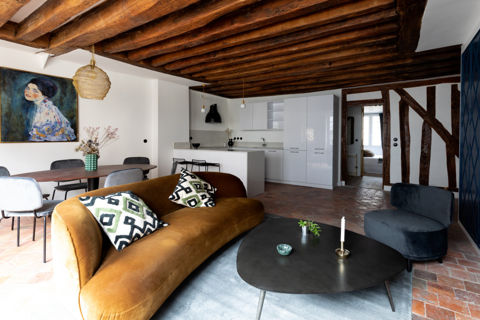 Exemple d'une salle de séjour tendance de taille moyenne et ouverte avec un mur blanc, tomettes au sol, une cheminée standard, un manteau de cheminée en carrelage, un téléviseur dissimulé et un sol rouge.