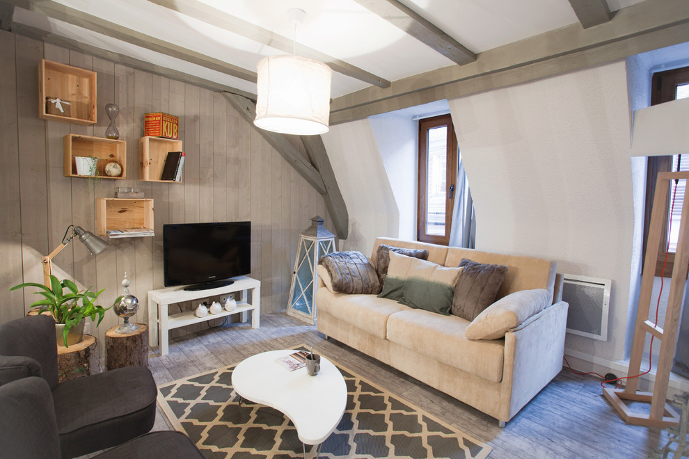 Ispirazione per un soggiorno chic di medie dimensioni con pareti beige, pavimento in legno massello medio, nessun camino e TV autoportante