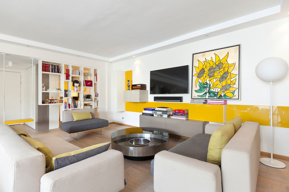 Foto di un grande soggiorno design aperto con libreria, pareti bianche, parquet chiaro e TV a parete