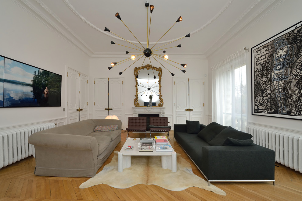 На фото: большая изолированная гостиная комната в современном стиле с белыми стенами, светлым паркетным полом и коричневым диваном без камина, телевизора с