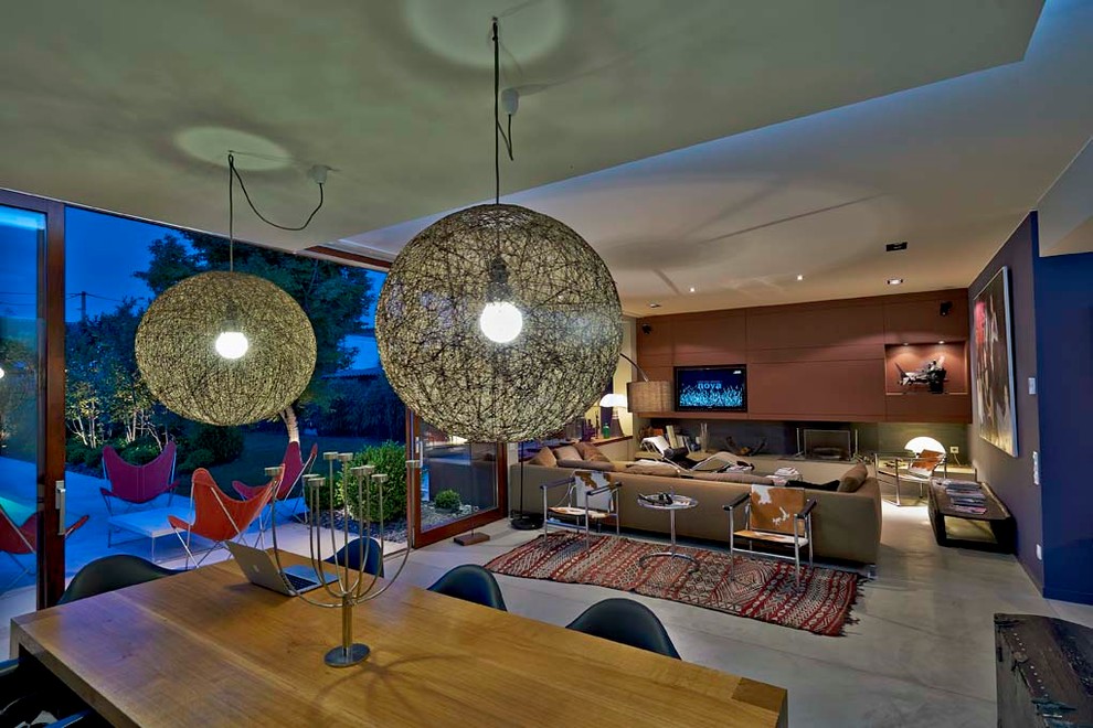 На фото: большая открытая гостиная комната в современном стиле с коричневыми стенами и телевизором на стене с