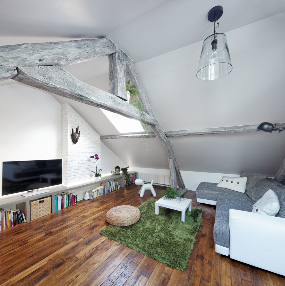 Imagen de sala de estar cerrada actual pequeña sin chimenea con televisor independiente, paredes blancas y suelo de madera en tonos medios