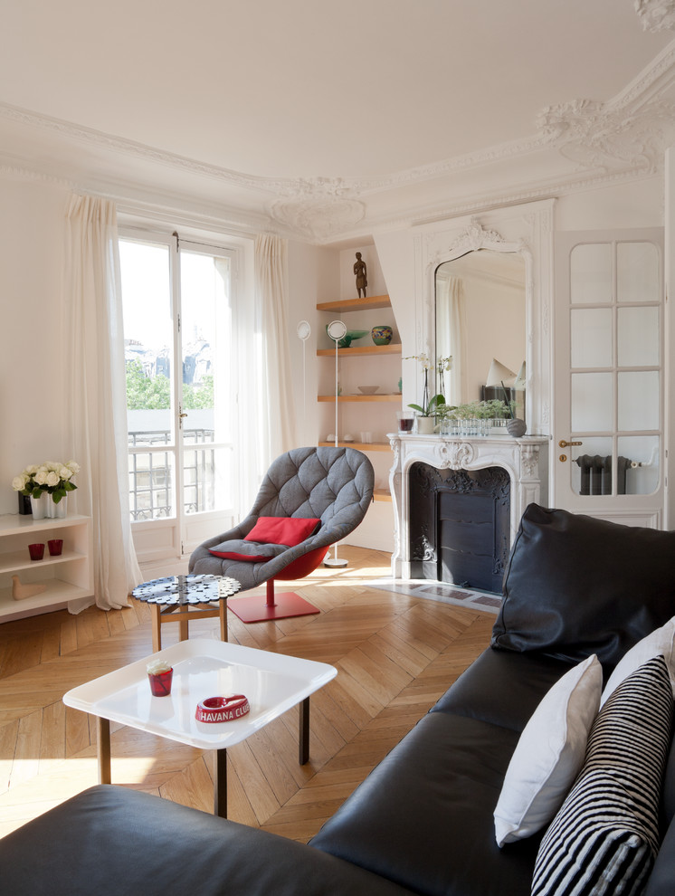 Modernes Wohnzimmer mit weißer Wandfarbe, braunem Holzboden und Kamin in Paris