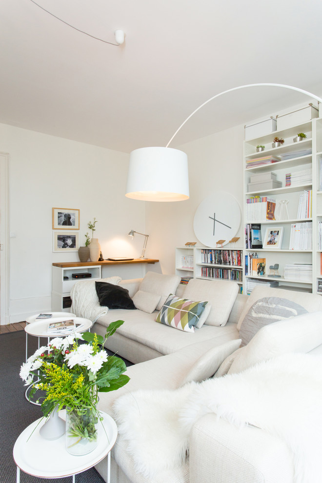 На фото: изолированная гостиная комната среднего размера в скандинавском стиле с с книжными шкафами и полками и белыми стенами без камина, телевизора с