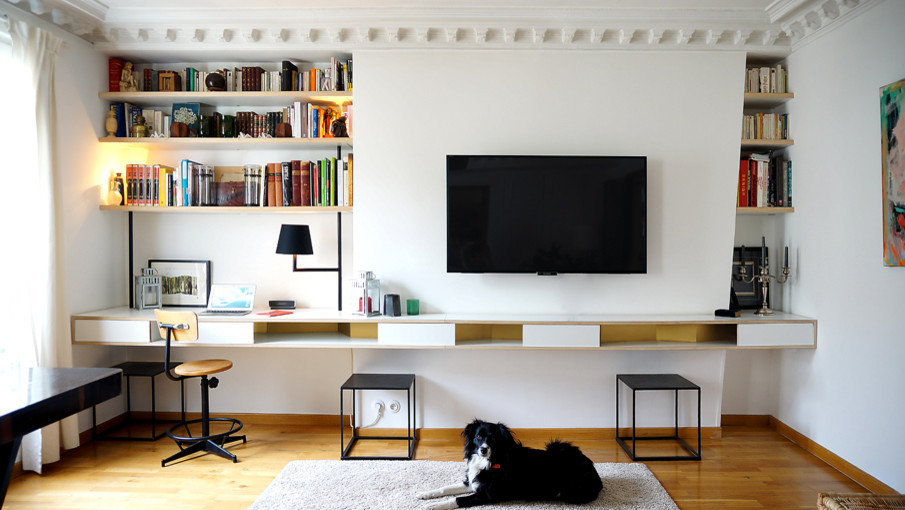 Источник вдохновения для домашнего уюта: гостиная комната среднего размера в современном стиле с с книжными шкафами и полками, белыми стенами, паркетным полом среднего тона и телевизором на стене