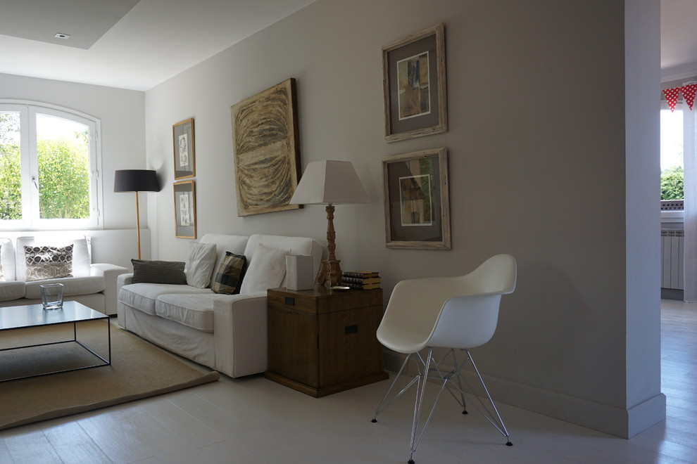 На фото: большая открытая гостиная комната в стиле неоклассика (современная классика) с с книжными шкафами и полками, серыми стенами, светлым паркетным полом и белым полом