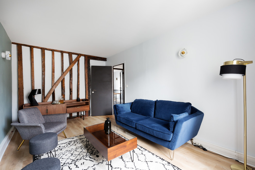 Modelo de sala de estar cerrada tradicional renovada con paredes blancas, suelo de madera clara y suelo beige