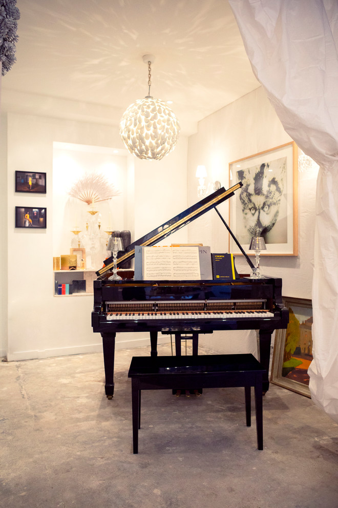 Exemple d'une petite salle de séjour éclectique avec sol en béton ciré, une salle de musique et un mur blanc.