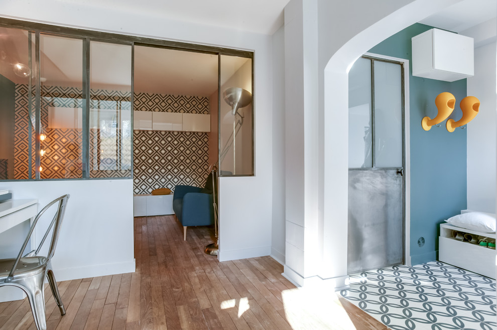 Imagen de sala de estar cerrada actual de tamaño medio con paredes azules y suelo de madera clara
