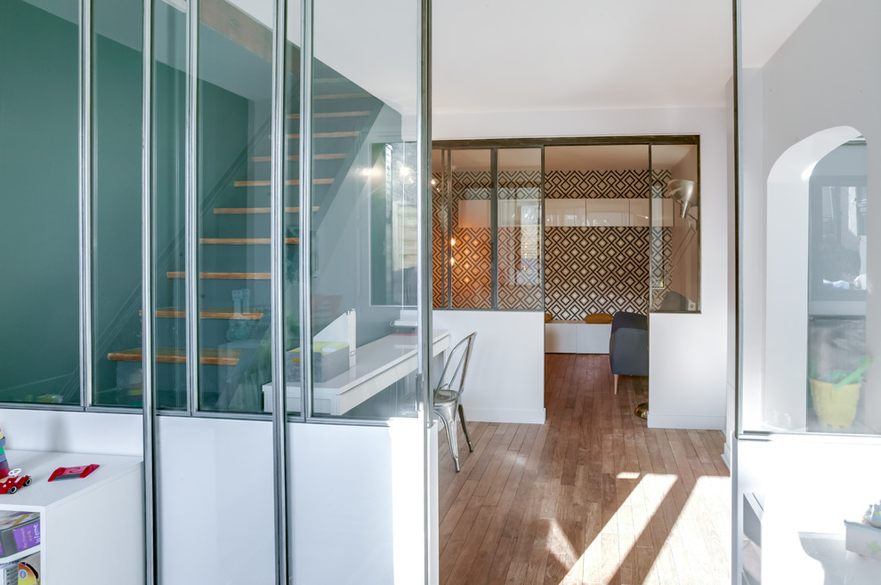 Idée de décoration pour une salle de séjour design de taille moyenne et fermée avec un mur bleu et parquet clair.
