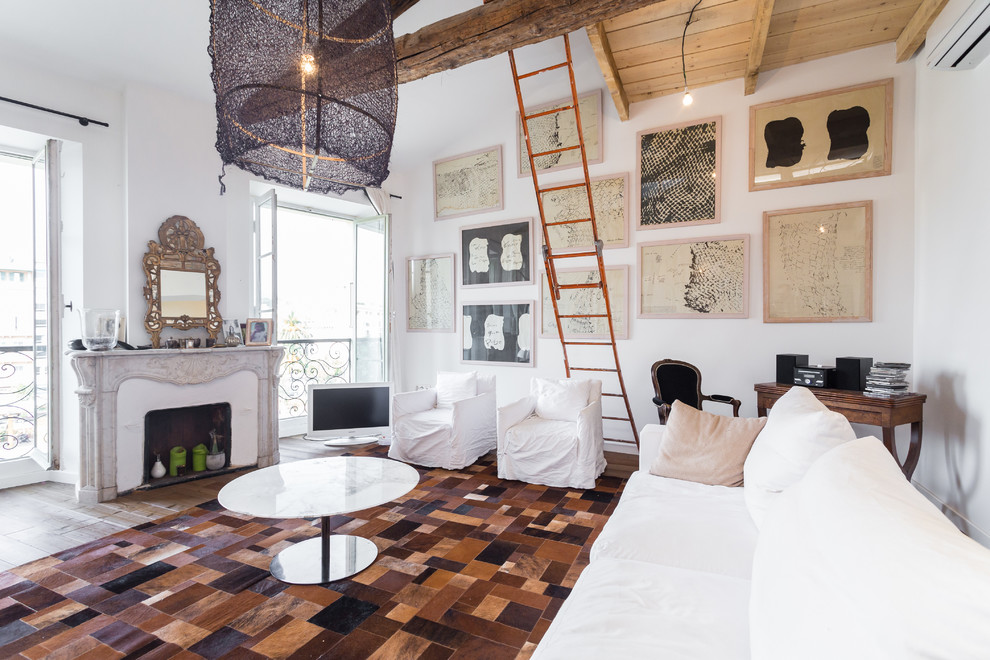 Diseño de sala de estar abierta ecléctica grande con paredes blancas, suelo de madera clara, todas las chimeneas y televisor independiente