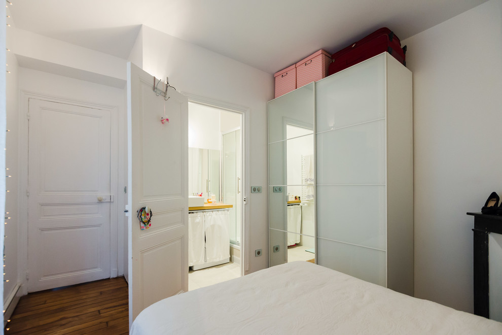 Offenes Modernes Wohnzimmer mit braunem Holzboden, weißer Wandfarbe, Kaminofen und Kaminumrandung aus Backstein in Paris
