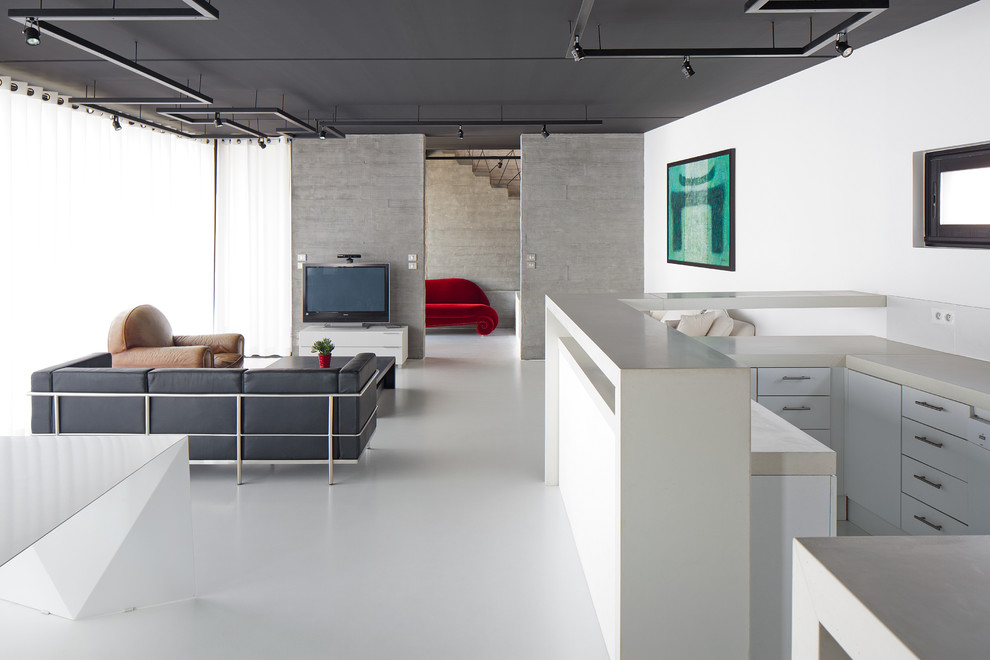 Modern inredning av ett stort allrum med öppen planlösning, med vita väggar, en fristående TV och vinylgolv