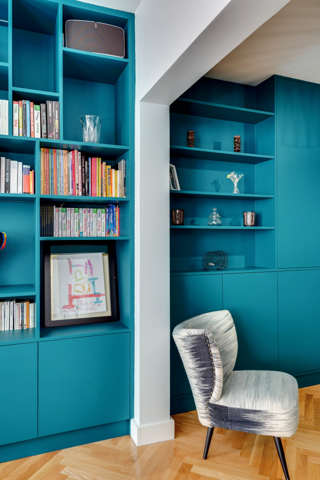 Idee per un grande soggiorno design aperto con libreria, pareti blu, parquet chiaro, nessun camino, TV a parete e pavimento beige