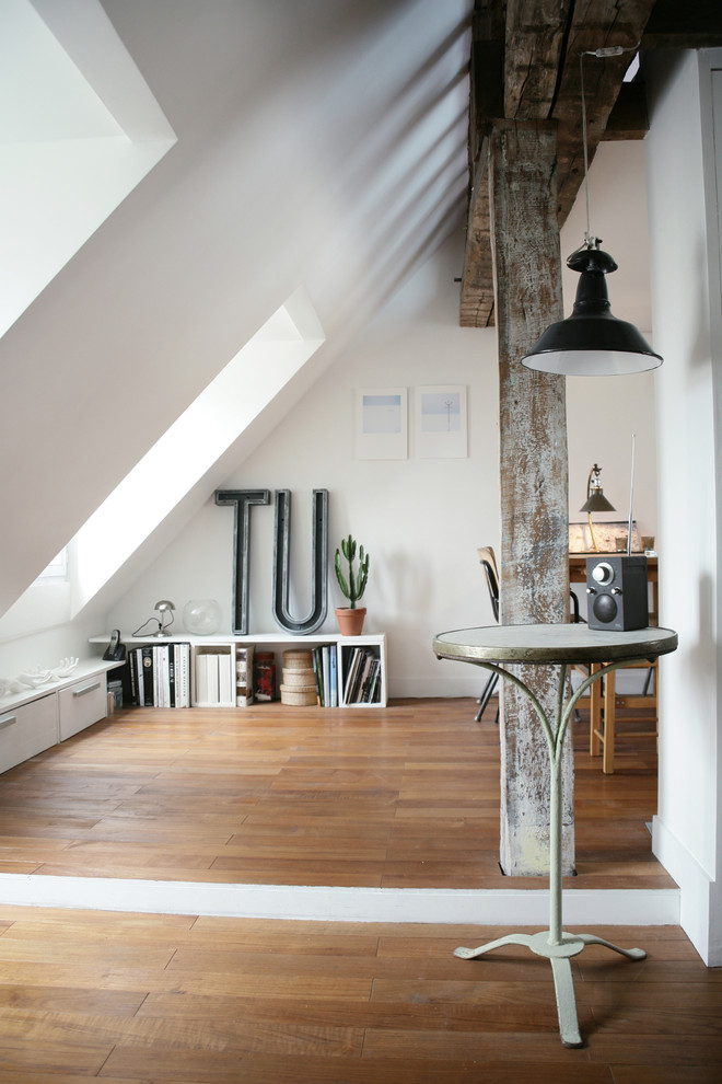 Esempio di un soggiorno design di medie dimensioni con libreria, pareti bianche e pavimento in legno massello medio