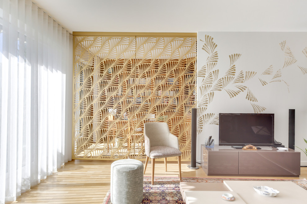 Imagen de sala de estar abierta contemporánea grande sin chimenea con paredes verdes, suelo de madera clara, televisor independiente y suelo beige