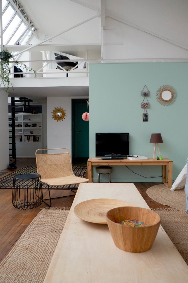 Diseño de sala de estar abierta escandinava de tamaño medio sin chimenea con suelo de madera en tonos medios, televisor independiente y paredes multicolor