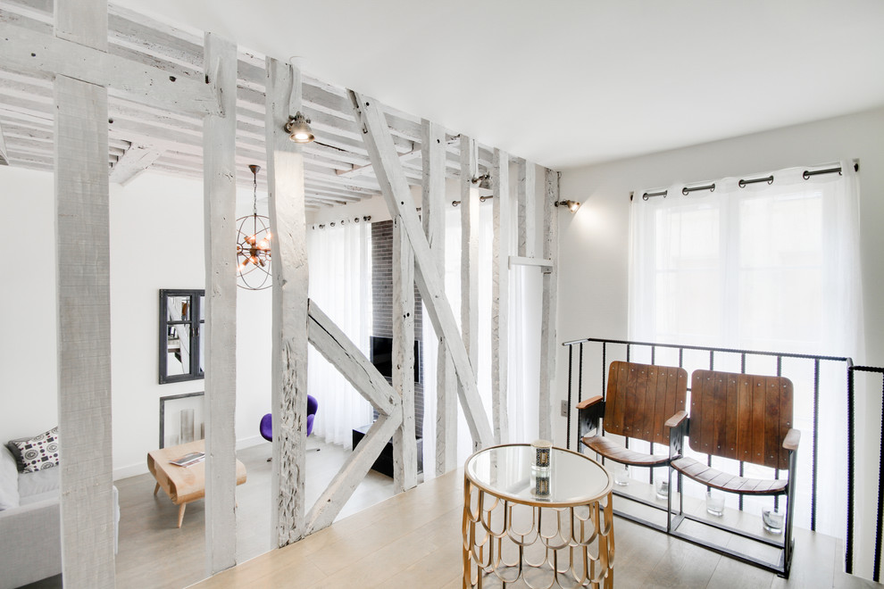 Diseño de sala de estar tipo loft urbana con paredes blancas y suelo de madera clara