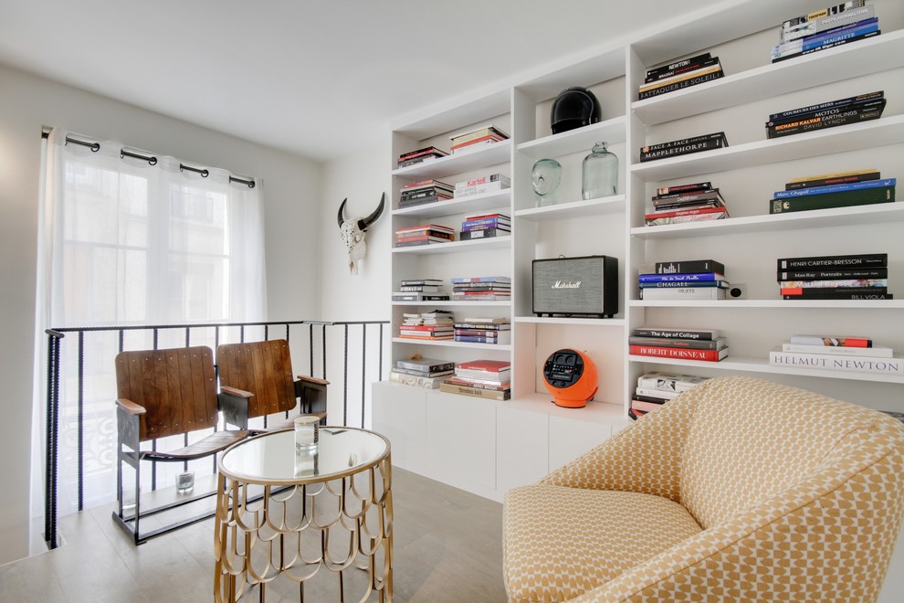 Стильный дизайн: двухуровневая гостиная комната среднего размера в стиле фьюжн с с книжными шкафами и полками и белыми стенами без камина, телевизора - последний тренд