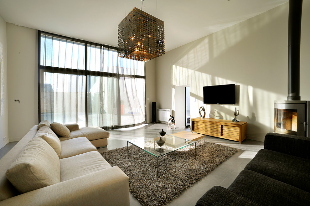 Modelo de sala de estar contemporánea con paredes beige y televisor colgado en la pared