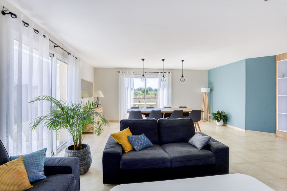 Modelo de sala de estar escandinava con paredes azules, suelo de baldosas de terracota, televisor en una esquina y suelo beige