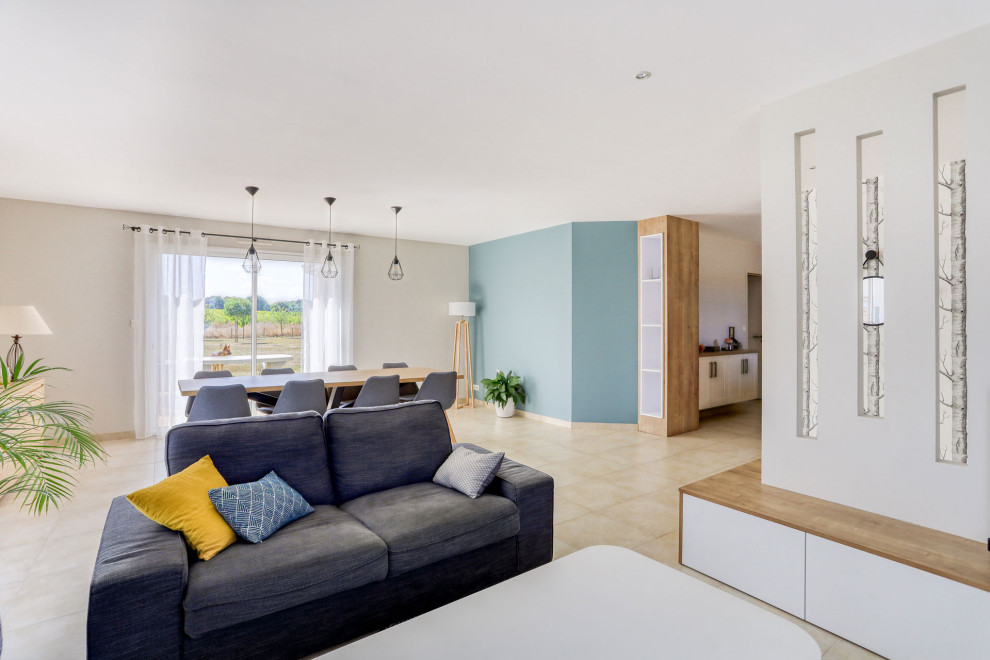 Skandinavisches Wohnzimmer mit blauer Wandfarbe, Terrakottaboden, Eck-TV und beigem Boden
