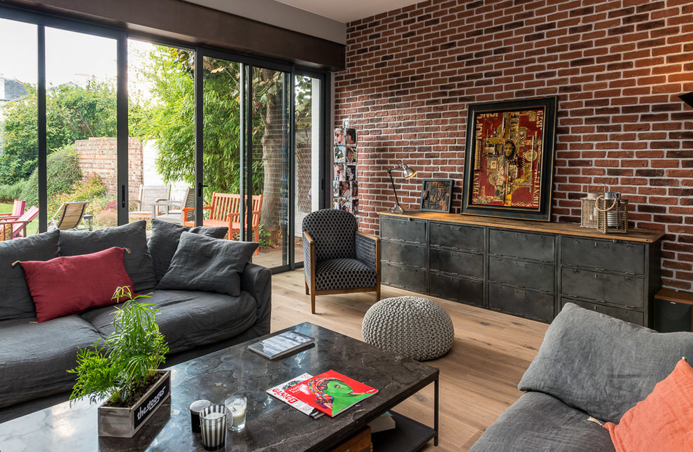Immagine di un soggiorno eclettico di medie dimensioni e aperto con pareti rosse, pavimento in legno massello medio e nessuna TV