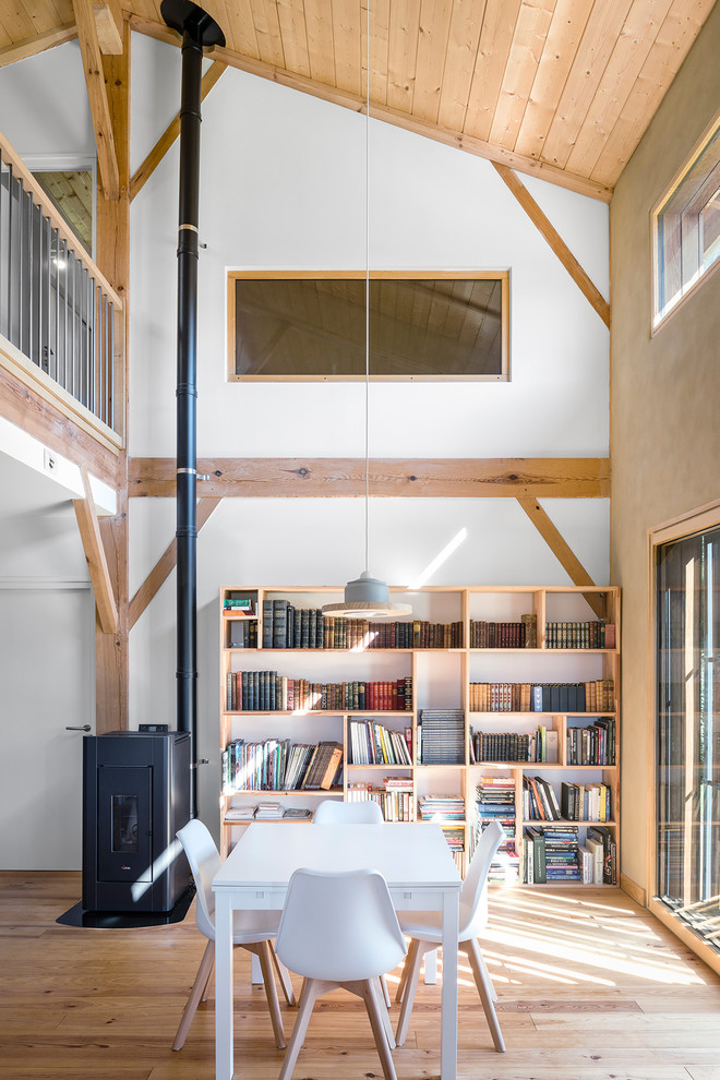 Идея дизайна: гостиная комната в стиле кантри с с книжными шкафами и полками, светлым паркетным полом и печью-буржуйкой