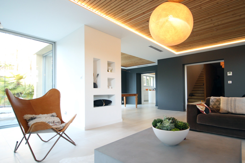 Großes, Fernseherloses, Offenes Modernes Wohnzimmer ohne Kamin mit schwarzer Wandfarbe, Betonboden und grauem Boden in Bordeaux
