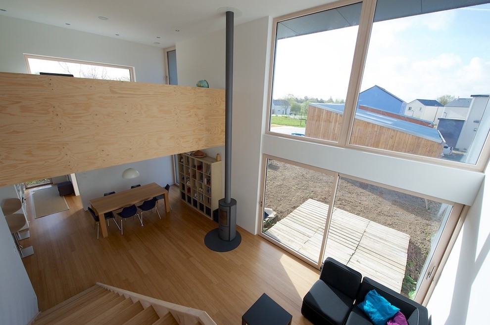 На фото: открытая гостиная комната среднего размера в современном стиле с белыми стенами и полом из бамбука без телевизора