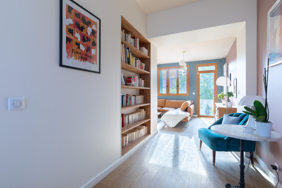 Idéer för ett mellanstort modernt allrum, med ett bibliotek, rosa väggar och ljust trägolv