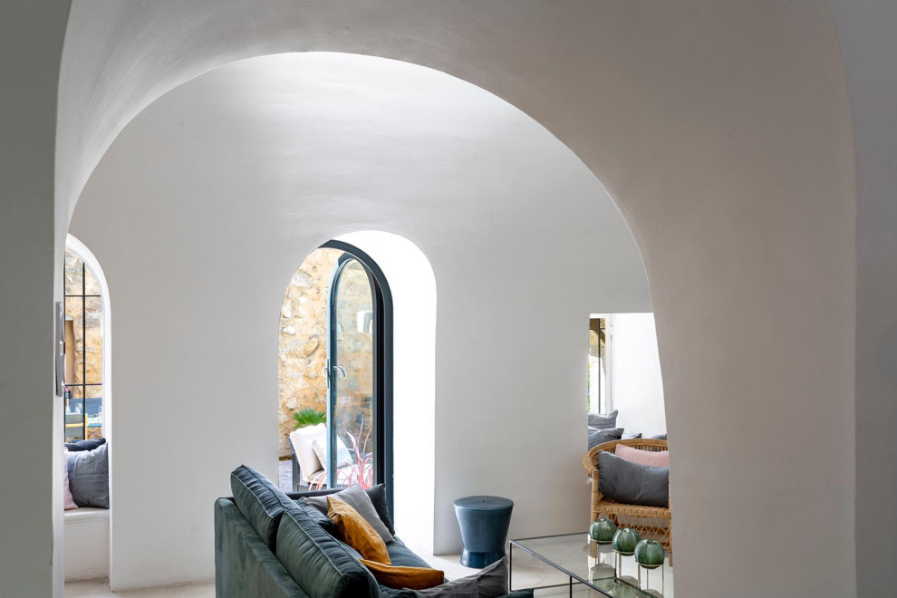 Imagen de sala de estar bohemia de tamaño medio con paredes blancas, todas las chimeneas, marco de chimenea de piedra y suelo multicolor