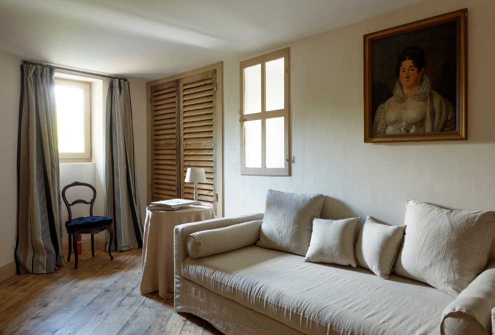 Aménagement d'une grande salle de séjour méditerranéenne ouverte avec un mur beige, aucun téléviseur et un sol beige.