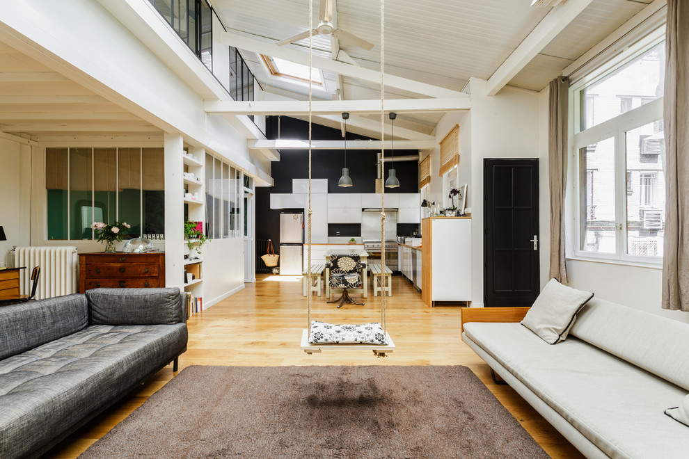 Großes, Offenes, Fernseherloses Industrial Wohnzimmer ohne Kamin mit schwarzer Wandfarbe und hellem Holzboden in Paris