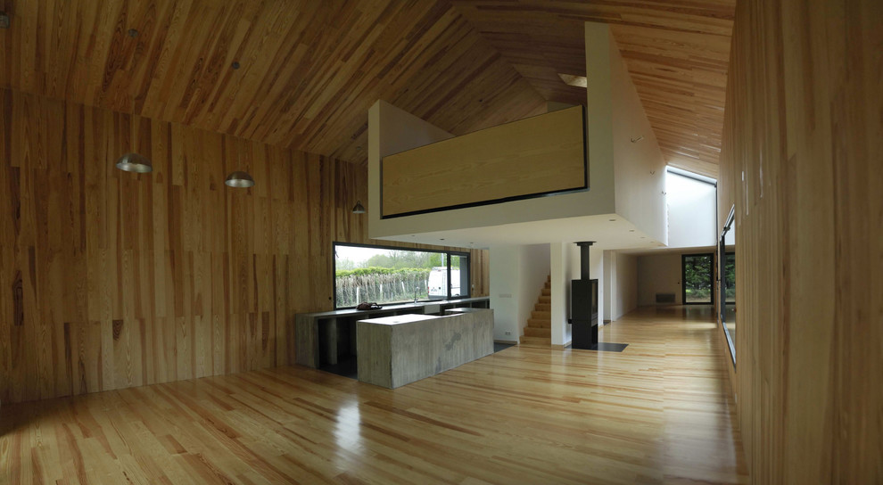 Foto de sala de estar abierta actual grande sin televisor con paredes marrones y suelo de madera en tonos medios