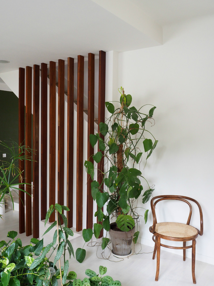 Cette image montre une salle de séjour design de taille moyenne avec un mur vert et parquet peint.