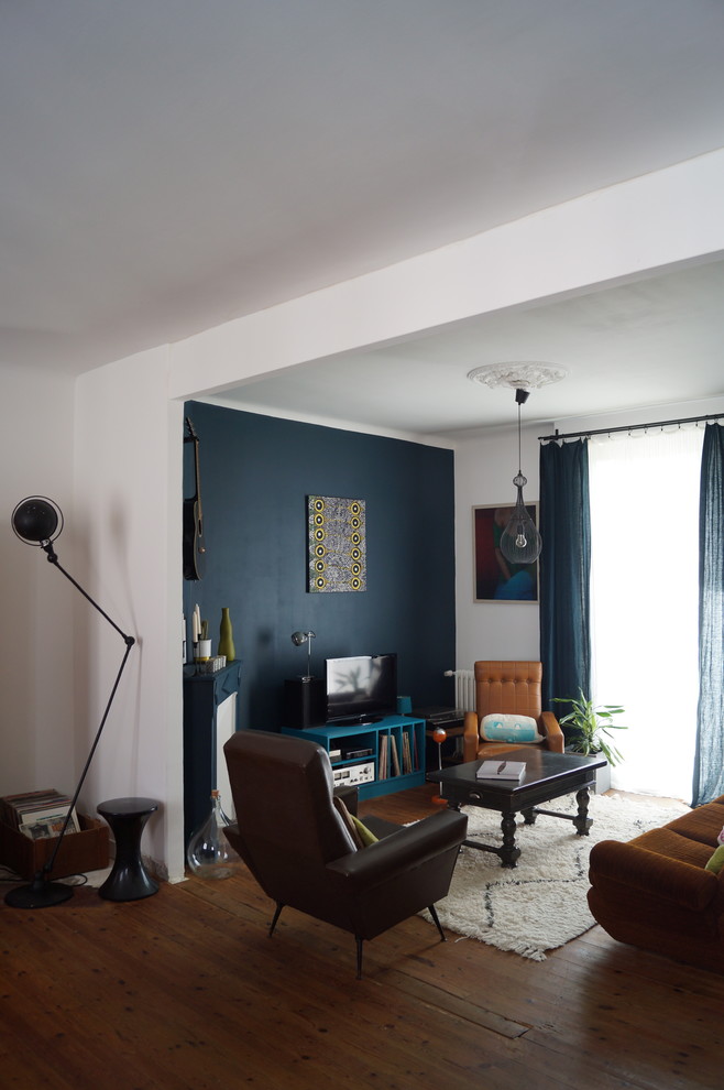 Идея дизайна: открытая гостиная комната среднего размера в современном стиле с паркетным полом среднего тона, отдельно стоящим телевизором и разноцветными стенами