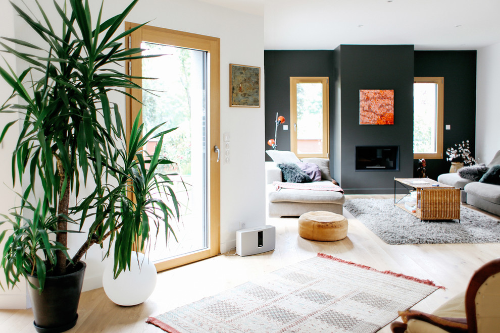 Réalisation d'une salle de séjour design ouverte avec un mur gris, parquet clair, une cheminée standard et un manteau de cheminée en métal.