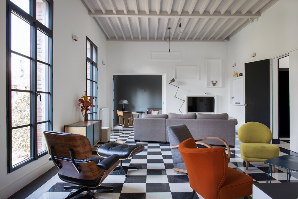 Modelo de sala de estar abierta moderna con paredes blancas, suelo de baldosas de cerámica, televisor colgado en la pared y vigas vistas