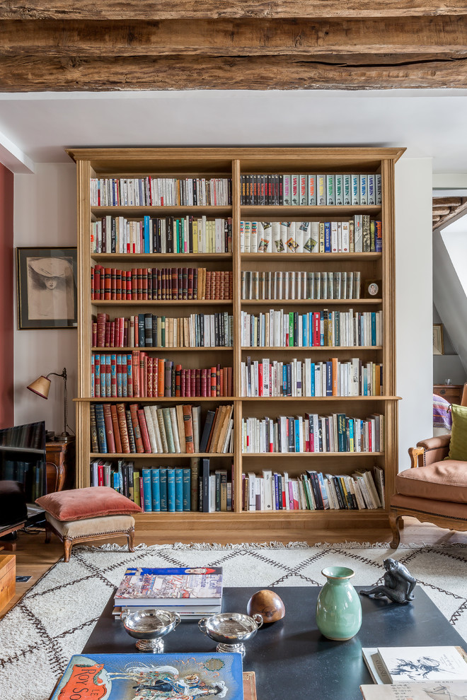 Inspiration pour une salle de séjour méditerranéenne avec une bibliothèque ou un coin lecture, un mur blanc, un sol en bois brun, un téléviseur indépendant et un sol marron.
