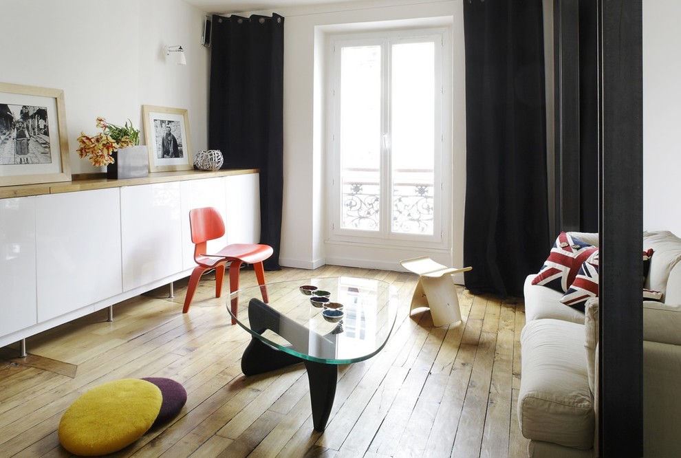 Imagen de sala de estar cerrada actual de tamaño medio sin televisor con paredes blancas y suelo de madera en tonos medios