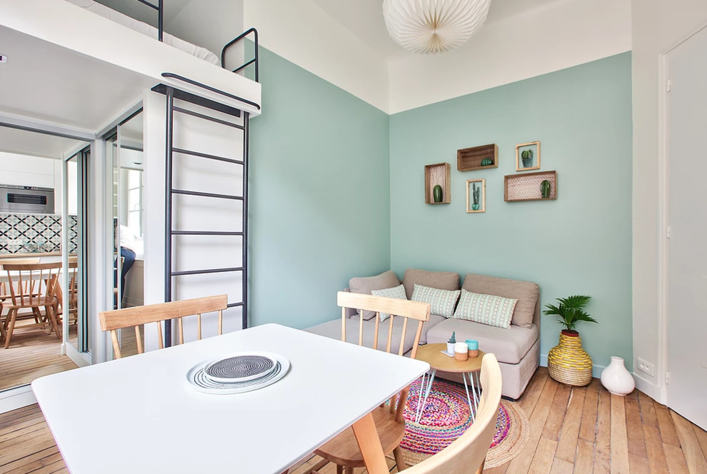 Foto di un piccolo soggiorno minimal stile loft con pareti verdi, pavimento in legno massello medio, TV a parete e pavimento marrone
